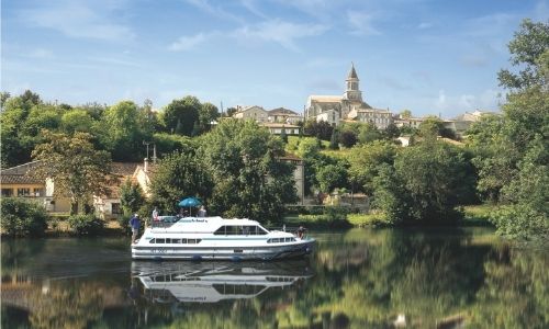 Un village paisible de Charente avec un bateau sans permis en premier plan