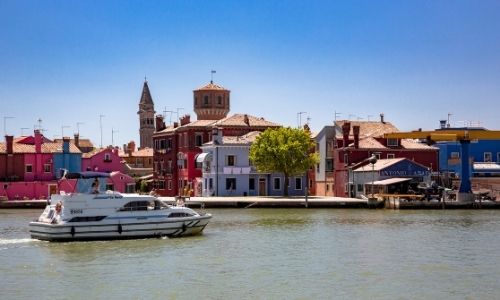Le bateau de location Leboat navigue devant les bâtiments colorés de Venise