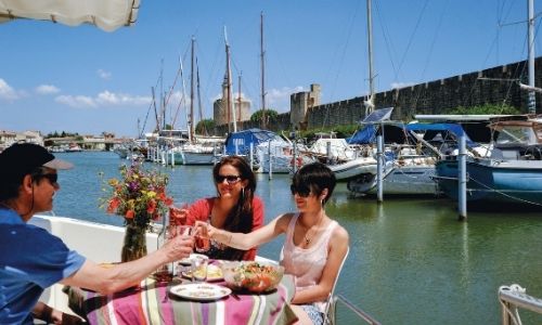 Un déjeuner en bateau sur le port d’Aigues-Mortes avec les remparts en fond