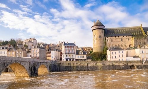 Les berges de la ville de Laval donne vue sur le château. L'eau de la rivière est terne et boueuse